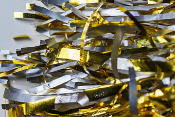 A macro close-up of shiny gold and silver metallic tinsel strips. A festive background perfect for...