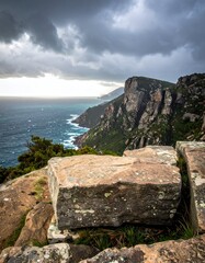 Rugged coastal landscape with cliffs, ocean, and a storm overhead