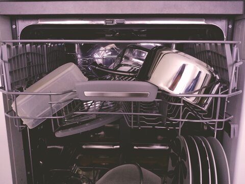 Photo d'un bac sup&eacute;rieur de lave vaisselle (propre) pris de profil, tiroir du bas ouvert, avec de la vaisselle propre