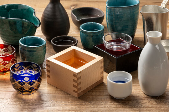 枡やぐい呑みなどの酒器が散りばめられた和の雰囲気の木製テーブル