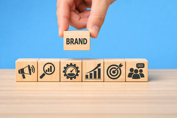 Brand strategy and marketing development concept with business icons and hand placing brand block above