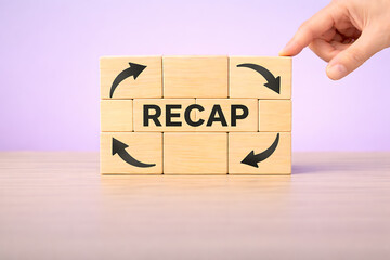 Business recap and performance review concept with circular arrows and recap text on wooden blocks