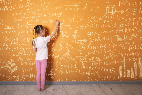 Young girl writes complex mathematical formulas on orange wall, symbolizing learning, education, creativity, and academic achievement. - Powered by Adobe