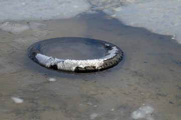 An old car tire at the bottom of a city river.Environmental pollution concept.