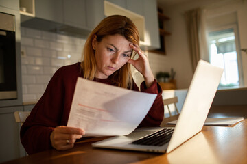 Worried woman reviewing household bills at home