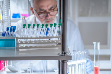 Experienced senior scientist working in a modern laboratory, carefully analyzing chemical samples. Concept of professional research, chemistry expertise, scientific methodology and laboratory science