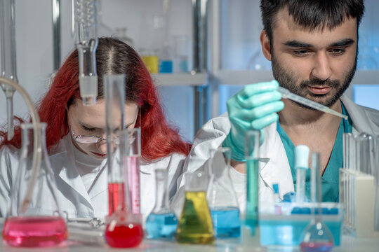 Young female and male students working together in a science laboratory. STEM education, teamwork, collaborative learning and modern academic research concept. - Powered by Adobe