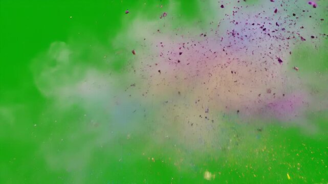 A dynamic explosion of vibrant colored powder in pink blue yellow and purple against a stark green background. Fine particles and wisps of smoke create a sense of motion and energy.