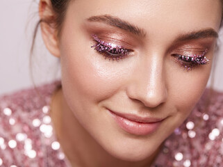 Close up portrait of a woman with a pink glittery trendy makeup 