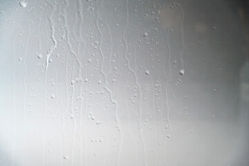 A close-up view of a gray painted surface featuring vertical liquid streaks and drips, creating a grunge industrial background for design projects