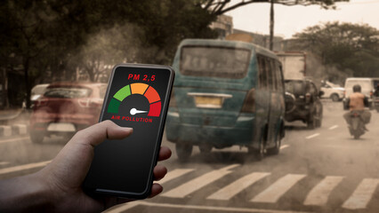 A person uses a smartphone app to measure dangerous PM 2.5 air pollution levels in a hazy, traffic-heavy city. Concept for environmental monitoring, urban health, and smart technology