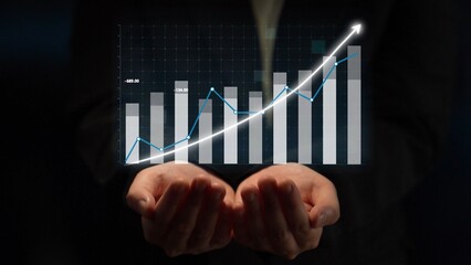 Hands supporting a growing chart with bars and a line graph, representing financial growth and business success in a modern digital landscape. Copula