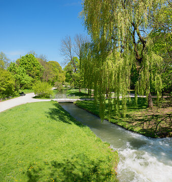 View into the park towards the Eisbach in Munich, seen from Prinzregentenstrasse road.
