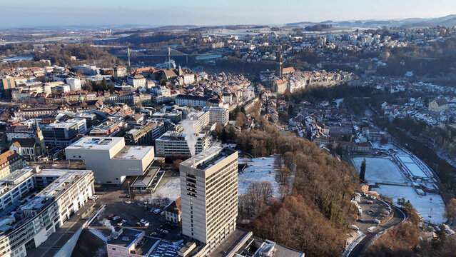 Aerial winter view of Fribourg old town with St. Nicholas Cathedral and Poya Bridge, Switzerland