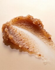 Hyper-realistic studio photography of cosmetic textures, swatch of a dark brown coffee sugar scrub on a beige gradient background