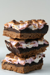 Three chocolate bars with marshmallows on top of each other. The bars are stacked on top of each other, creating a tower of deliciousness