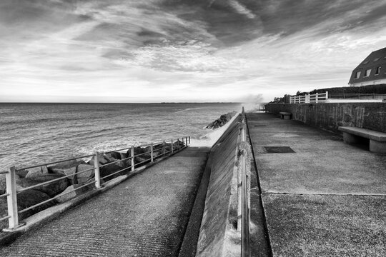 Sea waves crashing against the Hauteville-sur-Mer  riprap in Normandy coast
