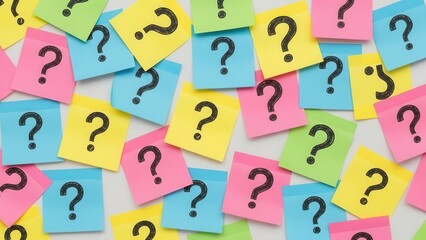 Vibrant collection of colorful sticky notes with black question marks scattered on a surface