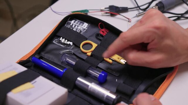 Skilled maker arranging components inside compact carrying case carefully, Professional working meticulously with specialized tools in well lit studio environment for repair tasks