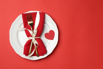 Beautiful table setting on red background, top view. Space for text