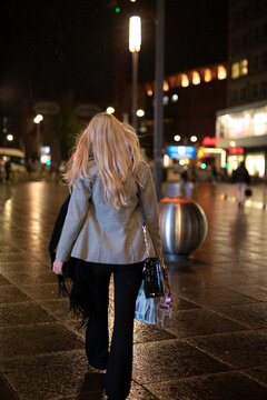 young woman walking on the street at night