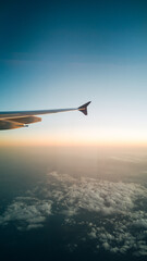 Fototapeta premium Breathtaking View from an Airplane Window, Looking Over White Clouds and Blue Sky in Bright Natural Sunlight