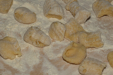 Fresh homemade gnocchi dusted with flour on a wooden board, a perfect rustic food background for cooking blogs, restaurant menus, and Italian cuisine projects