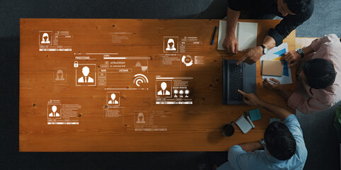 Professionals engage in data analysis and discussion in a modern workspace, showcasing digital elements and teamwork over a collaborative table setting. Trope