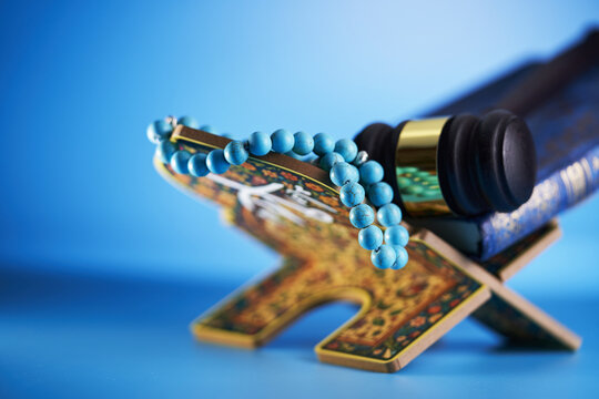 holy koran on book stand prayer beads and gavel