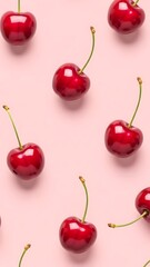 Fresh cherries arranged on a soft pink background creating a visually appealing pattern