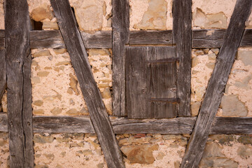 Old wooden beams on historic stone wall
