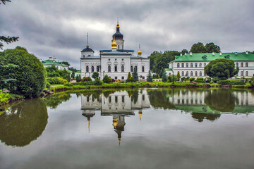 Monastery grounds with a pond and a view of the Cathedral of the Three Holy Hierarchs. Spaso-Eleazarovsky Convent. Elizarovo village, Pskov Oblast, Russia
