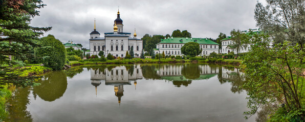 Monastery grounds with a pond and a view of the Cathedral of the Three Holy Hierarchs. Spaso-Eleazarovsky Convent. Elizarovo village, Pskov Oblast, Russia
