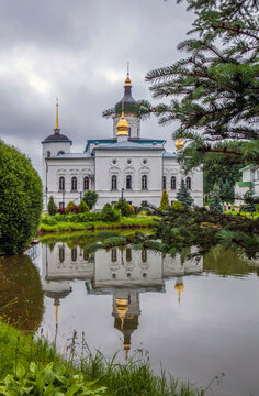 Monastery grounds with a pond and a view of the Cathedral of the Three Holy Hierarchs. Spaso-Eleazarovsky Convent. Elizarovo village, Pskov Oblast, Russia