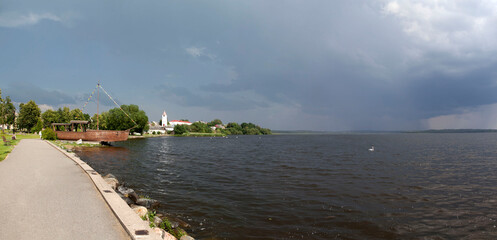 Picturesque Lake Sebezhskoye, Swan Square with a boat-shaped pavilion on the shore and a view of the Bell Tower of the Cathedral of the Nativity of Christ. Sebezh, Pskov Oblast, Russia