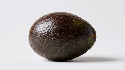 Whole avocado on a plain background with smooth surface texture