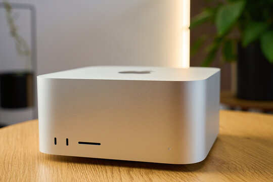 Apple Mac Studio Max desktop computer on wooden desk. High performance professional workstation from Apple on table