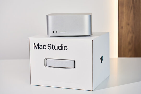 Apple Mac Studio Max desktop computer displayed in front of original retail box. High performance professional workstation from Apple on white background