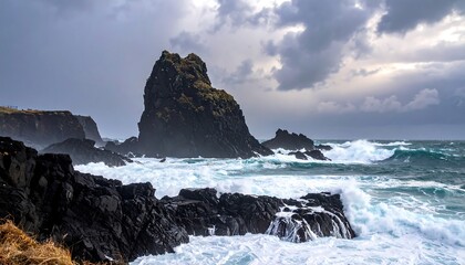 Coastal scene shows waves crashing against black rocks, under a stormy, cloudy sky