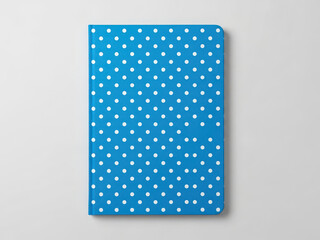 Blue polka dot notebook against gray background