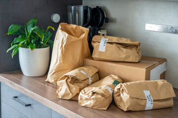 Meal kit ingredients sorted by recipe and placed on the kitchen counter. Concept of convenient...