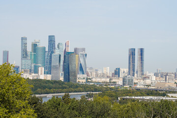 Fototapeta premium Skyscrapers of Moscow’s business district view with Moskva river and green city public park in foreground. Famous travel destination