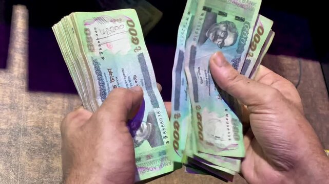 Close-up of Hands Counting a Stack of Bangladeshi 500 Taka Banknotes