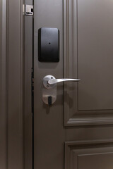 Obraz premium Hotel room door with electronic key card lock and metal handle, modern security access system and minimalist interior design