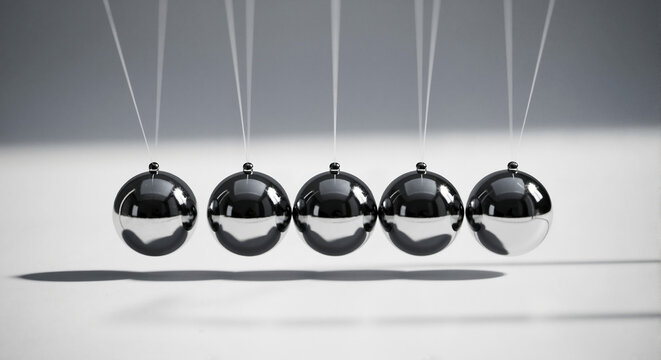 Five metal balls in motion demonstrating Newton's cradle physics  