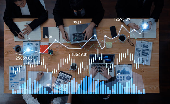 A team of professionals engages in a collaborative business meeting, analyzing financial data and trends with modern technology in an innovative workspace environment. Scalp - Powered by Adobe