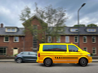 Fototapeta premium Yellow taxi car driving on city street, motion blur