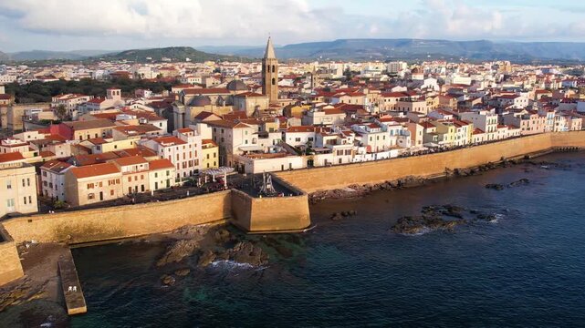 Explore Alghero, Sardinia from above, capturing its stunning historic buildings, coastal features, and vibrant streets. Experience the beauty of this Mediterranean gem.