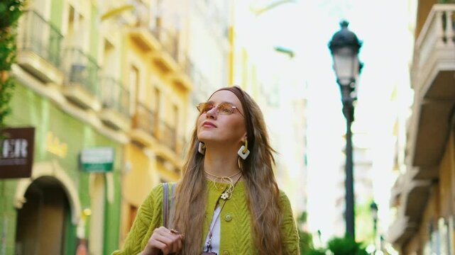 Young woman exploring vibrant urban alley in fashionable outfit