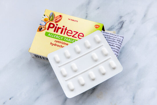 London. UK- January 14.2026. A close up of the packet and contents of Piriteze tablets for the treatment of allergy such as hay fever, isolated on a white marble background.